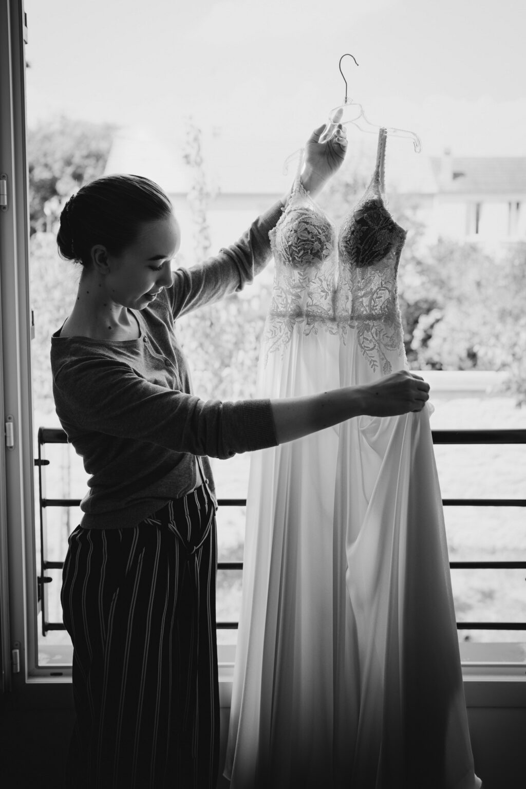 Future mariée qui regarde sa robe avant de la mettre
