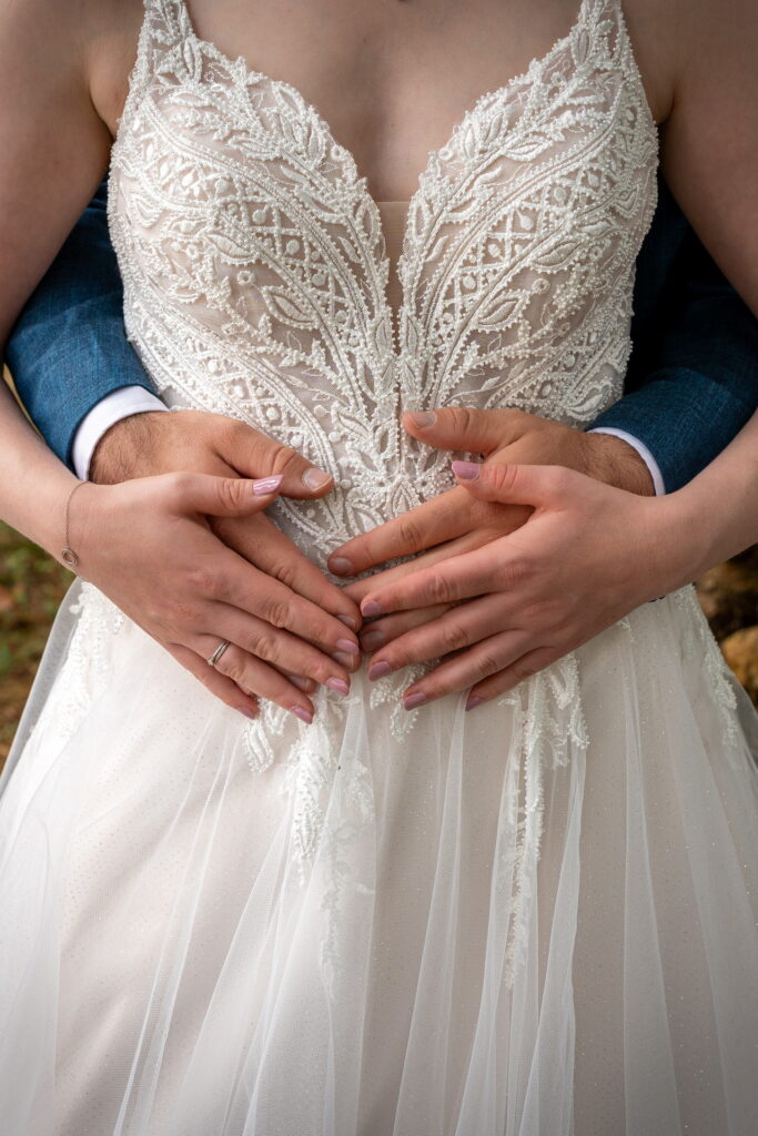 Cœur avec les mains sur la robe de la mariée
