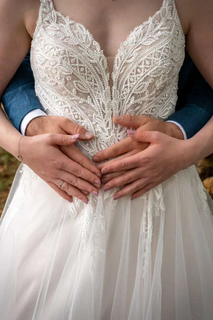 Cœur avec les mains sur la robe de la mariée