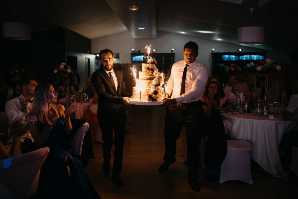 Le traiteur apporte le gâteau de mariage pendant la soirée aux Domaines de Gaston