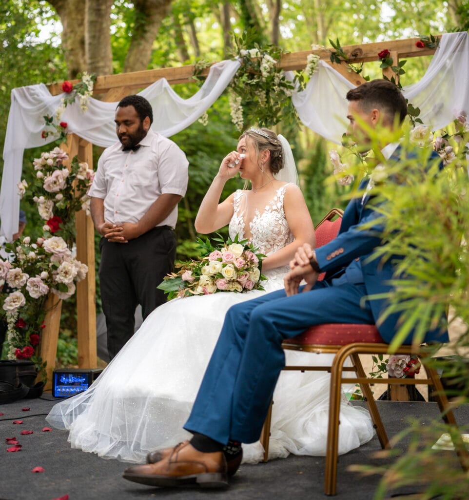 La mariée s’essuie les yeux avec un mouchoir pendant la cérémonie religieuse aux domaines de Gaston