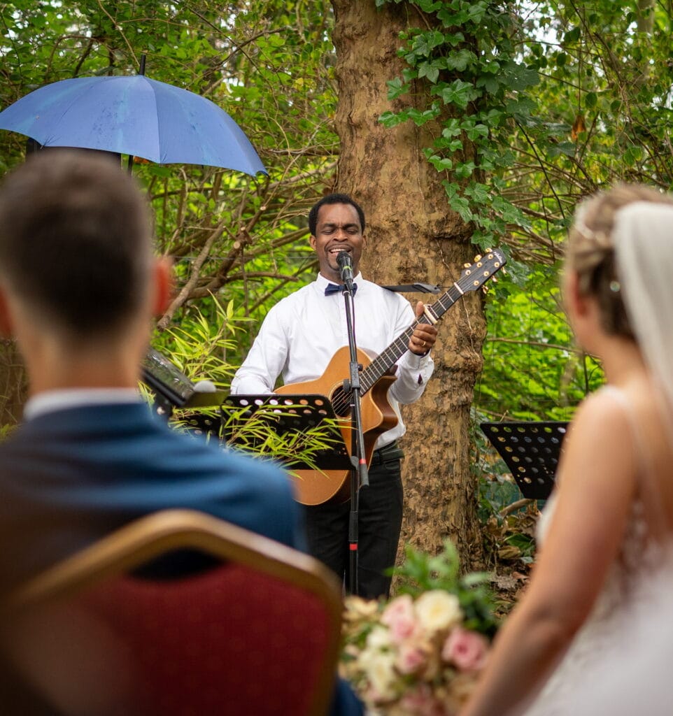 Chanteur jouant de la guitare aux Domaines de Gaston pendant la cérémonie de mariage